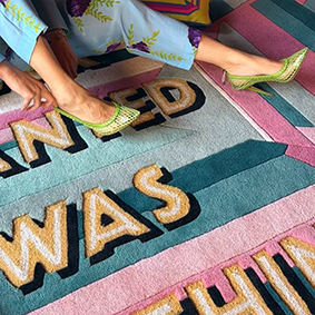 All I Ever Wanted Was Everything Pastel Gem Rug in pink, teal and yellow, seen from above with a person standing on it