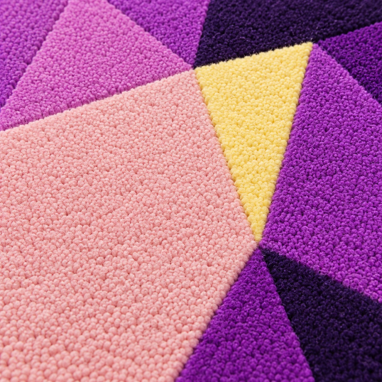 Close-up of the facets on the Amethyst Drop Gem Rug lightening from grape to lilac toward the point