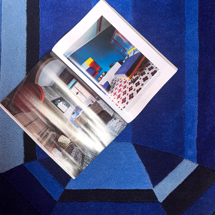 Blue Sapphire Emerald Gem Rug seen from above with an open magazine resting on it