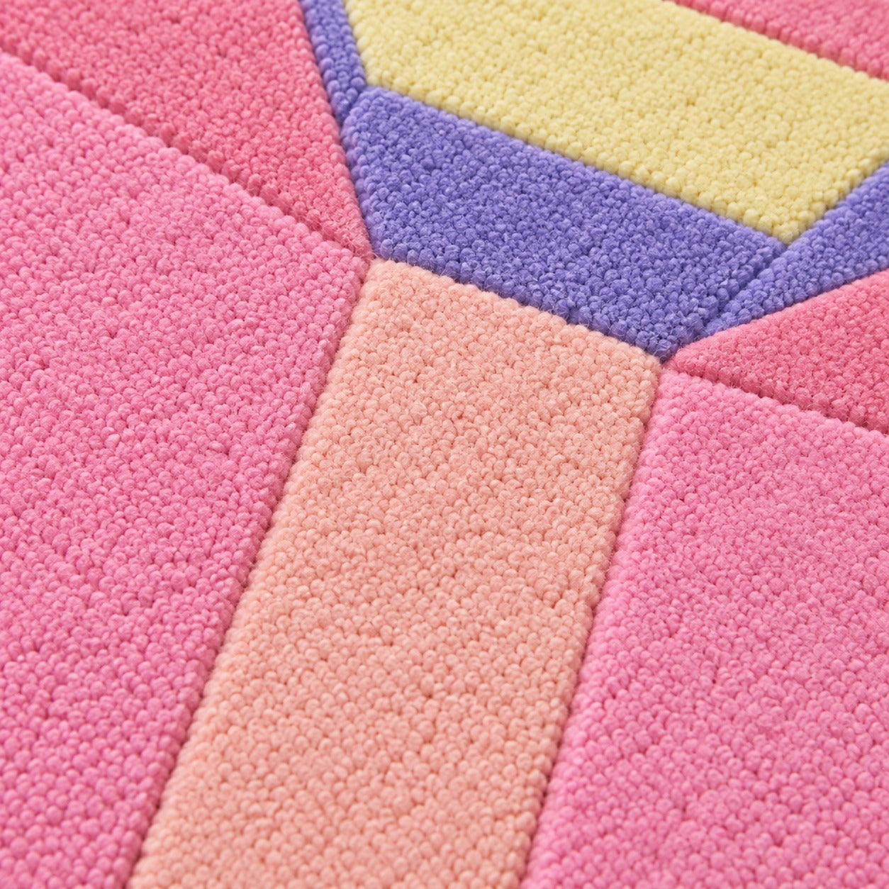 Close-up of the lilac, lemon, peach and blush facets on the Pastel Prism Emerald Gem Rug