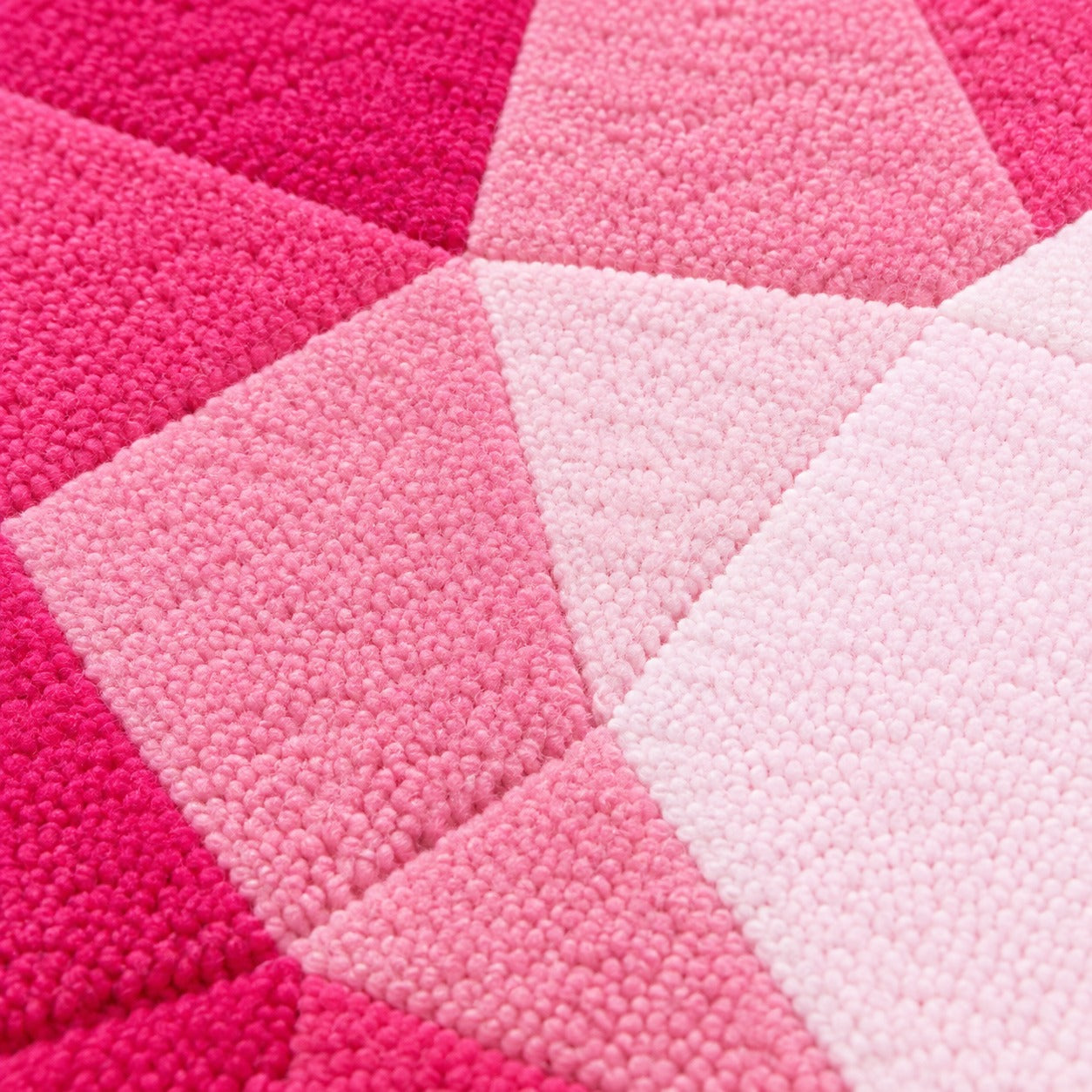 Close-up of the facets on the Rose Quartz Drop Gem Rug paling from dusty rose to soft petal pink at the point
