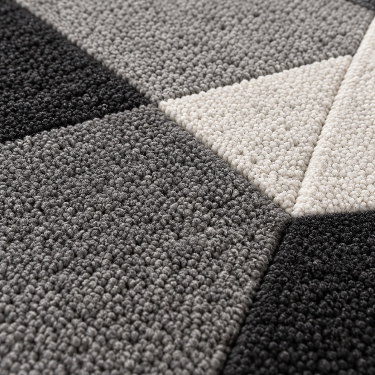 Close-up of the stepped facets on the Silver Gray Emerald Gem Rug in silver, dove gray and white
