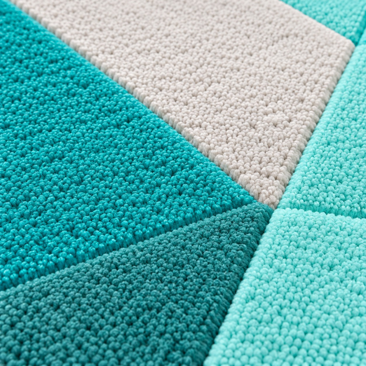 Close-up of the stepped facets on the Tia Emerald Gem Rug in pale milky blue, aqua and teal